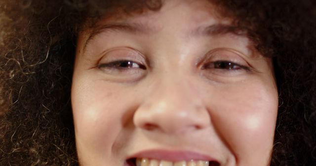 Close-Up of Smiling Woman with Curly Hair and Radiant Skin - Download Free Stock Images Pikwizard.com