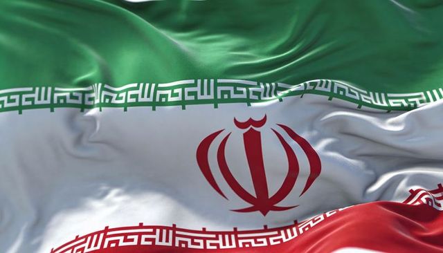 Waving iran flag close-up with emblem and kufic script border on silk texture