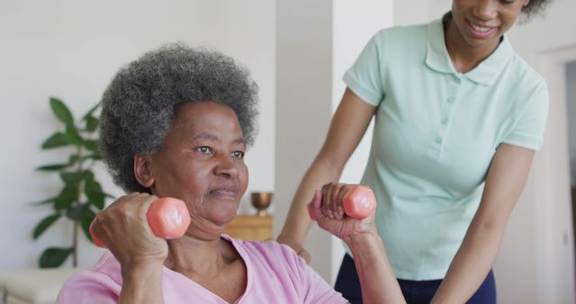 Senior Woman Exercising with Hand Weights Assisted by Caregiver Indoors - Download Free Stock Images Pikwizard.com