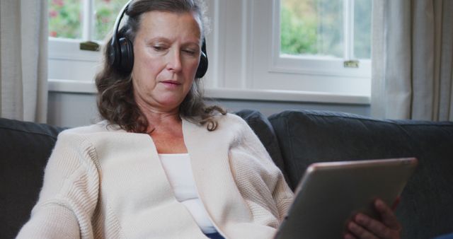 Mature Woman Relaxing with Headphones and Tablet at Home - Download Free Stock Images Pikwizard.com