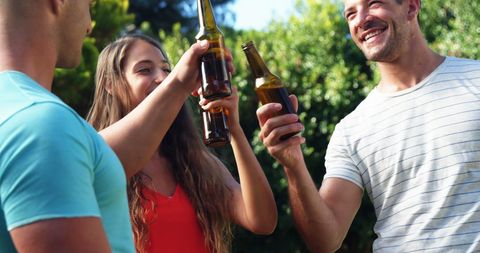 Young Friends Toasting with Beer in Relaxed Outdoor Gathering