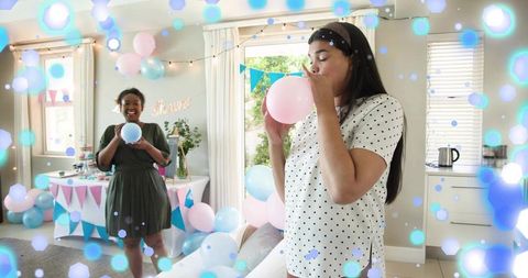 Expectant mother baby shower preparing balloons with friend in pastel living room