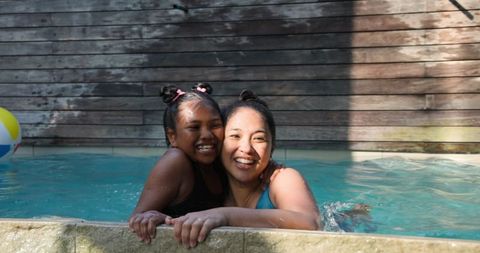 Asian Mother and Daughter Bonding in Outdoor Swimming Pool
