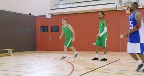 African american player driving to basket facing double team on indoor basketball court
