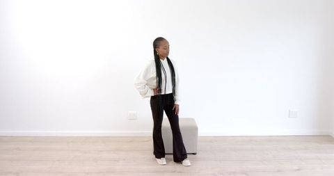 Confident girl standing stylishly in modern minimalist room