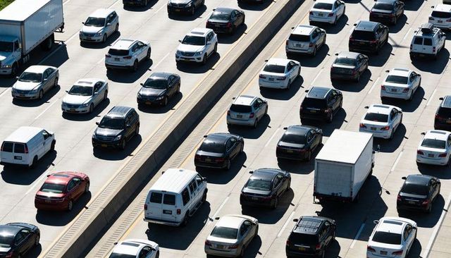 Sunlit aerial overhead freeway showing rush hour congestion with cars suvs vans truck