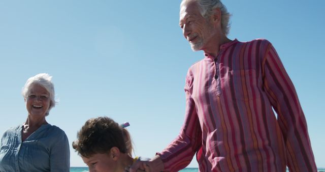 Grandparents Enjoying Beach Day with Grandchild - Download Free Stock Images Pikwizard.com