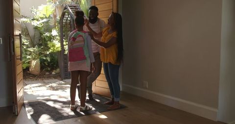 Family homecoming: parents embracing daughter after school