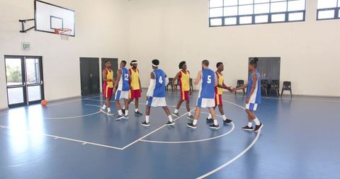 Basketball Players Shaking Hands Before Game in Indoor Gym