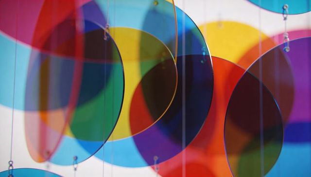 Hanging translucent color discs overlapping creating vibrant abstract circular mobile