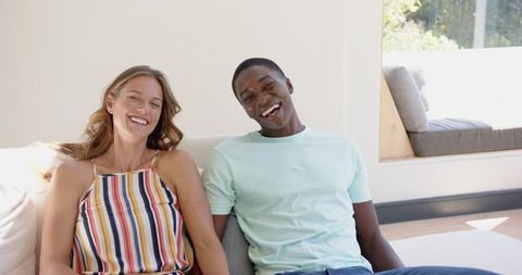 Happy Diverse Couple Relaxing Indoors on Sunny Day