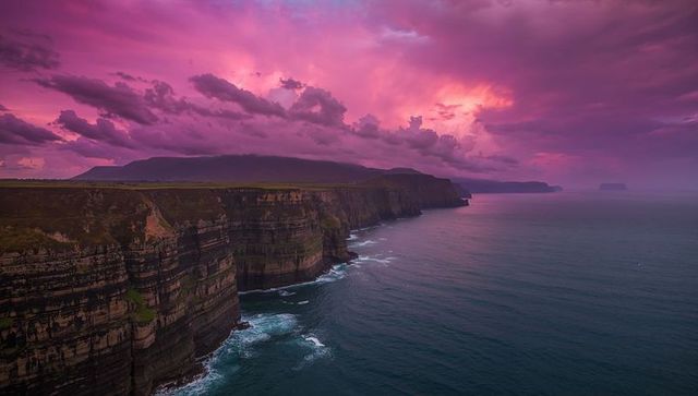Dramatic sunset over majestic cliffs and ocean waves