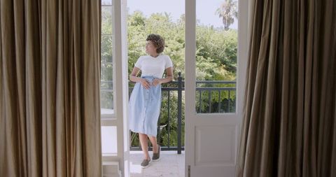 Woman Enjoys Tranquil Balcony View on Sunny Day