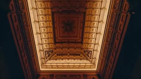 Operator tilting upward revealing ornate coffered ceiling with central medallion and cornice