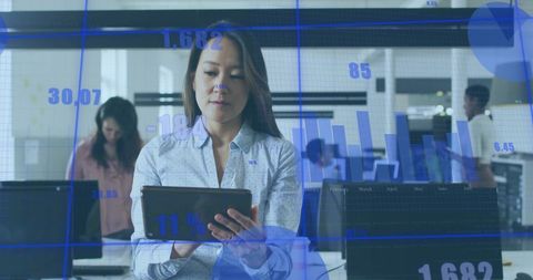 Businesswoman Analyzing Financial Data with Digital Tablet in Office