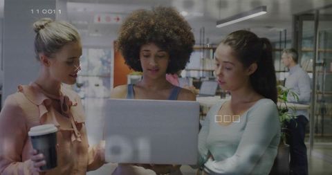 Team of Three Women Collaborating on Laptop in Open Office
