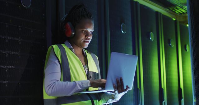 African american female computer technician using laptop working in business server room - Download Free Stock Photos Pikwizard.com