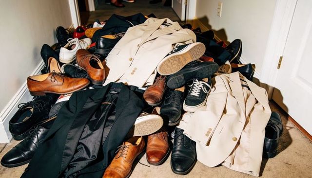 Overflowing hallway pile of shoes and blazers creating chaotic entryway clutter and wardrobe mess