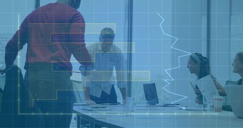 Team Collaborating Over Data Visualization in Glass Boardroom with Laptop Presentations