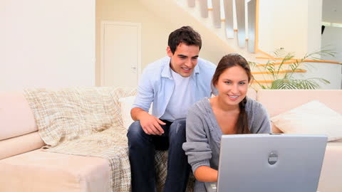 Happy Couple Using Laptop in Cozy Living Room