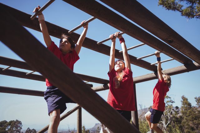 Kids climbing monkey bars during obstacle course training in the boot camp
