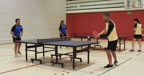 Diverse Group Enjoying Table Tennis Match in Sports Hall