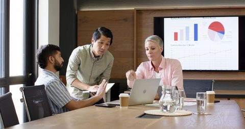 Diverse Team Analyzing Business Charts in Meeting Room