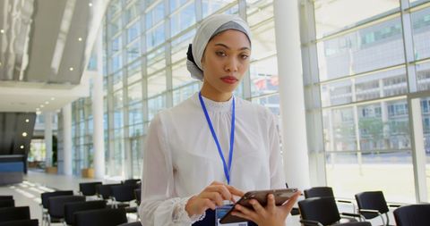 Confident Asian Businesswoman Using Tablet in Modern Office Lobby