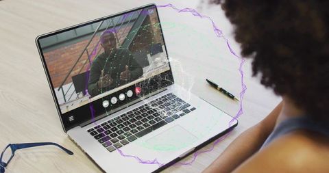 Remote collaboration showing laptop video call with presenter and holographic data overlay