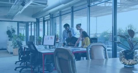 Diverse Team Collaborating Over Analytics Dashboard in Modern Open Office