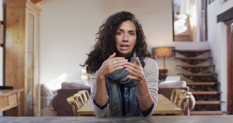 Caucasian Woman Having Video Call at Wooden Table in Cozy Home
