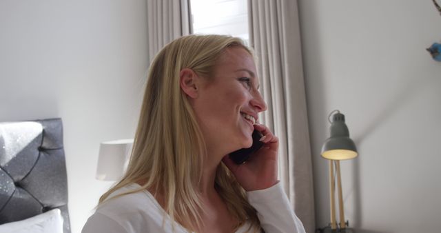 Smiling Woman Talking on Phone in Modern Bedroom - Download Free Stock Images Pikwizard.com