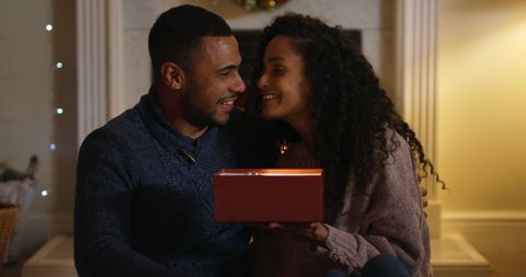 Couple Sharing a Gift in Warm Holiday Ambiance