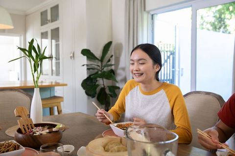 Young couple enjoying lunch asian cuisine in modern home