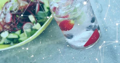 Healthy refreshment with iced fruit-infused water and fresh salad