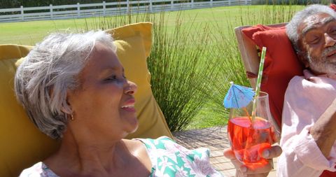 Senior Couple Relaxing with Cocktails in Sunny Backyard