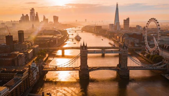 Tower bridge and river thames at golden hour with shard and london eye skyline