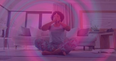 African american woman meditating at home on yoga mat in sunlit living room mindful living