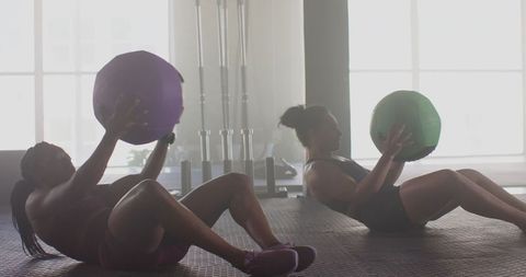 Women Engaged in Intense Medicine Ball Workout