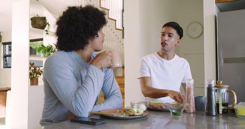 Young friends enjoying breakfast and conversation in contemporary kitchen