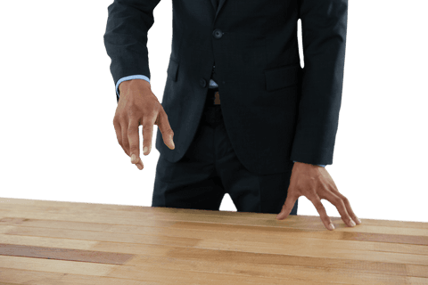 Transparent Businessman Gesturing at Wooden Table Mid-Section