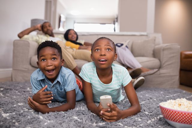 Surprised children watching television while parents sitting at home