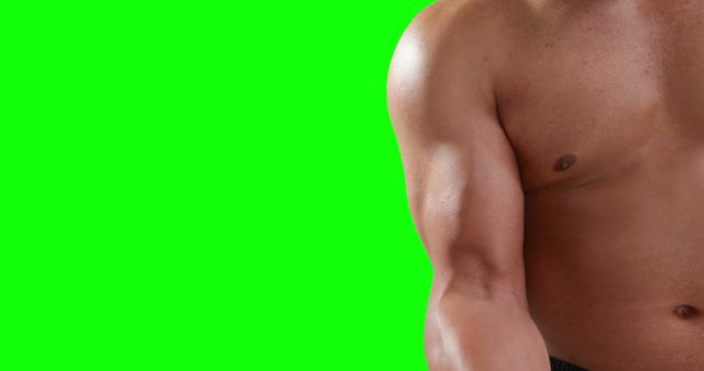 A young Caucasian man's torso is visible against a green screen background, with copy space. His physique suggests he might be an athlete or fitness enthusiast, and the green screen allows for various backgrounds to be superimposed.