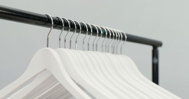 Row of Minimalist White Hangers on Black Rack - Download Free Stock Images Pikwizard.com