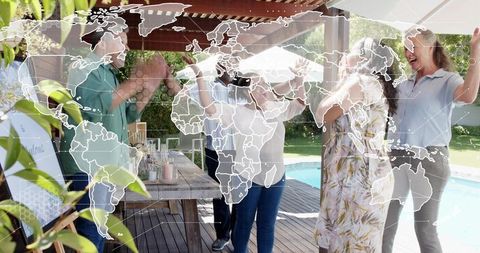 Intergenerational backyard celebration clapping around picnic table with world map overlay