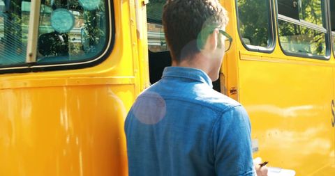 Teacher Guiding Students onto School Bus with Social Media Icons Overlay