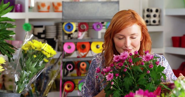 Portrait of beautiful female florist smelling bunch of sunflower in flower shop