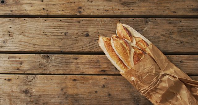 Image of baguettes in paper bag on a wooden surface. food, cuisine and catering ingredients.