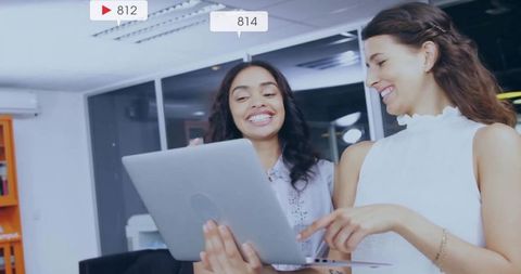 Women Reviewing Digital Metrics on Laptop in Office Environment