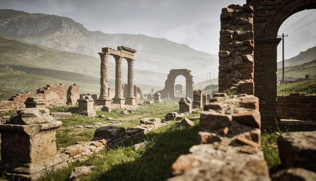 Weathered roman ruins with fluted columns and stone arch in misty mountain valley landscape